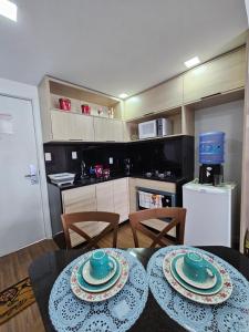 a kitchen and a table with two plates on it at Flat vista mar Boa Viagem in Recife