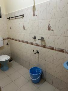 a bathroom with a toilet and a bucket in it at Mukalel Tourist Home in Ernakulam