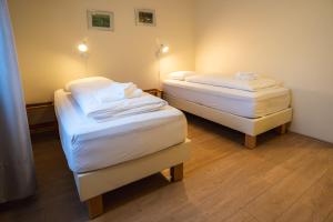 2 Betten in einem Zimmer mit weißer Bettwäsche in der Unterkunft Hotel Studlagil in Skjöldólfsstaðir