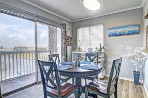 a dining room with a table and chairs and a large window at Mystic Harbor 301 in Padre Island