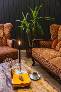 a candle on a table in a living room with chairs at Hotel Studlagil in Skjöldólfsstaðir