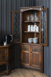 a wooden cabinet with cups and plates on it at Hotel Studlagil in Skjöldólfsstaðir