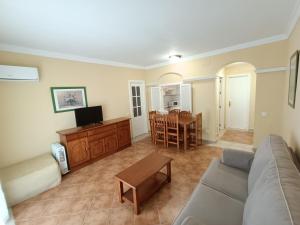 ein Wohnzimmer mit Sofa und Tisch in der Unterkunft PRECIOSO APARTAMENTO EN PRIMERA LÍNEA DE PLAYA in Isla Canela
