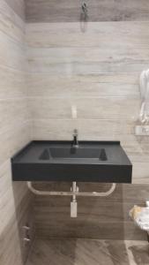 La salle de bains est pourvue d'un lavabo et d'un comptoir noir. dans l'établissement Hotel Splendid, à Diano Marina