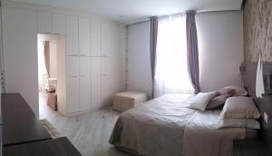 a white bedroom with a bed and a window at Hotel Splendid in Diano Marina