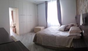 a white bedroom with a bed and a window at Hotel Splendid in Diano Marina