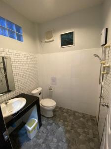 a bathroom with a toilet and a sink at Brown Andaman Krabi in Krabi