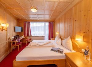 a hotel room with a bed and a desk at Hotel Latini in Zell am See