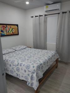 een slaapkamer met een bed met een bloemdekbed bij Espectacular cabaña en Coveñas - Sucre, Frente al mar!!! in Coveñas