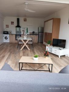 ein Wohnzimmer mit einem Tisch und einer Küche in der Unterkunft Leu doux bruit des vagues in Saint-Leu