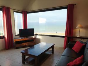 uma sala de estar com vista para a praia em Gîtes " Arromanches" ou "Bord de Mer PMR" 2 chambres en FRONT DE MER à Asnelles , 3km d'Arromanches, 10km de Bayeux em Asnelles