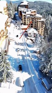 a city street covered in snow with a red arrow at Deluxe Apartment 33 Mountain Lodge Pamporovo in Pamporovo