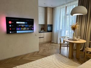 kuchnia ze stołem i telewizorem na ścianie w obiekcie Other Apartments w Iwano-Frankiwsku
