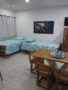 een woonkamer met 2 bedden en een tafel bij Espectacular cabaña en Coveñas - Sucre, Frente al mar!!! in Coveñas