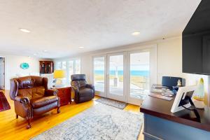 Ocean House في Nameloc Heights: غرفة معيشة مع كرسي ومكتب مع نافذة