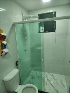 een badkamer met een toilet en een glazen douche bij Apartamento verão in Vila Velha