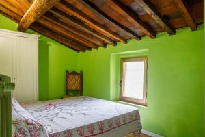 - une chambre verte avec un lit et une fenêtre dans l'établissement La Castellaccia, à Campagnatico
