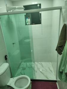 een badkamer met een glazen douche en een toilet bij Apartamento verão in Vila Velha