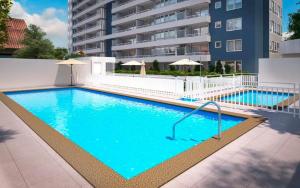 a large blue swimming pool next to a building at Depto Carvajal in Santiago