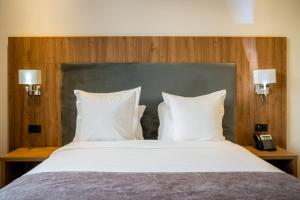 阿加迪爾的住宿－Dominium Hotel，卧室内的一张带白色枕头的大床