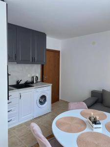 een woonkamer met een tafel en een keuken met een wasmachine bij Pirin Sense apartment A11 in Bansko