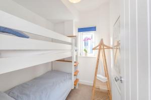 Bluebell Cottage Mumbles - Sea Views في ذا مامبلز: غرفة نوم صغيرة مع سرير بطابقين وسلم