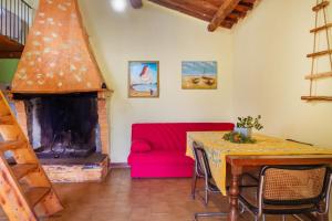 een woonkamer met een rode bank en een open haard bij La Castellaccia in Campagnatico