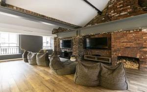 a living room with couches and a brick wall at Cosy Modern Studios at Sheffield 3 located near the University of Sheffield in Sheffield