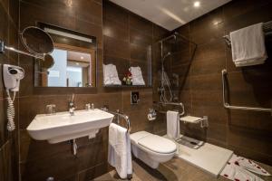 un bagno con lavandino, water e specchio di Dominium Hotel ad Agadir