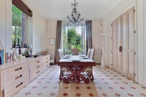 a large kitchen with a table and a chandelier at Villa Boileau - Welkeys in Paris