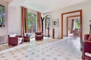 a living room with chairs and a large window at Villa Boileau - Welkeys in Paris