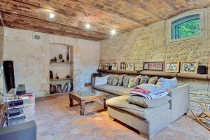 a living room with a couch and a stone wall at Villa Boileau - Welkeys in Paris