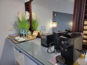 eine Küchentheke mit einer Kaffeemaschine darüber in der Unterkunft Studio climatisé dans Résidence avec piscine, à proximité de la mer in La Trinité