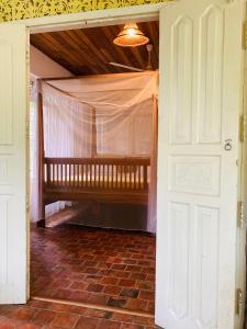 eine offene Tür mit einer Bank in einem Zimmer in der Unterkunft Whispering House in Tangalle