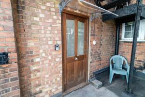 a brick building with a wooden door and a blue chair at hendon Central 2 bed room 20 minutes to central London in The Hyde