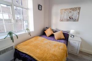 a bedroom with a bed with a yellow blanket at hendon Central 2 bed room 20 minutes to central London in The Hyde