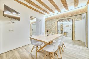 a dining room with a wooden table and white chairs at Casa Bidaiari by Clabao in Pamplona