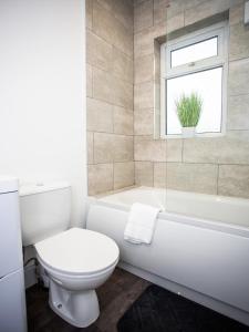 a bathroom with a toilet and a tub and a window at Langley Park House, Durham in Langley Park