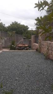 a picnic table in a yard next to a stone wall at Domenica Casa Hotel in La Cumbre
