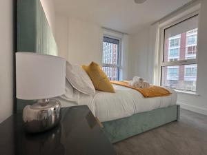 倫敦的住宿－Glitz and Luxury，一间卧室配有一张床和一张带台灯的桌子