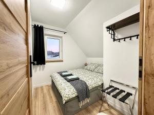 - une petite chambre avec un lit et une fenêtre dans l'établissement Domki Potok - Noclegi Bieszczady, à Stefkowa