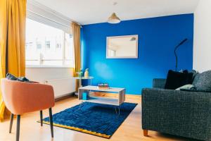 a blue living room with a couch and a table at Easy access to Cardiff City Centre & FREE Parking! in Cardiff