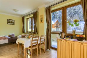 a kitchen and living room with a table and chairs at Willa Antidotum in Krynica Zdrój