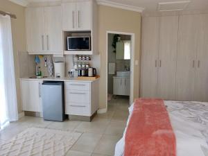 a kitchen with white cabinets and a counter top at 22's Company in Cape Town +7 photos