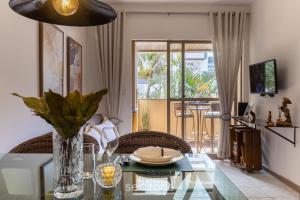 a living room with a glass table with a vase at Lindo apto a 650m da UFSC Floripa-SC IDC0102 in Florianópolis