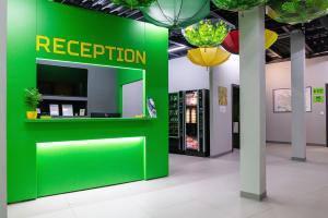 un espace de réception vert dans un bâtiment avec un mur vert dans l'établissement Green Cube Capsule Hostel, à Sofia