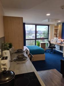 a room with a bed and a table with plates on it at Cosy Modern Studios at Sheffield 3 located near the University of Sheffield in Sheffield