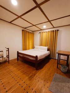 a bedroom with a bed and a wooden floor at Magnolia Hideout in Nuwara Eliya