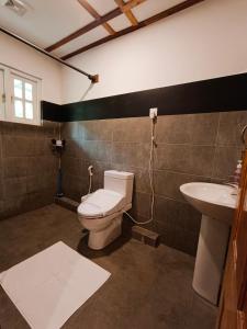 a bathroom with a toilet and a sink at Magnolia Hideout in Nuwara Eliya