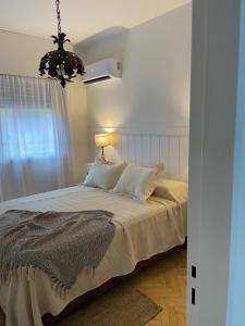 a bedroom with a bed and a chandelier at Dos Ambientes Deluxe Concordia Centro in Concordia